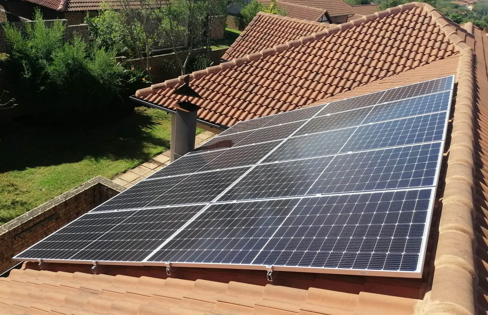 Solar panels on the red clay-tile roof of a family house